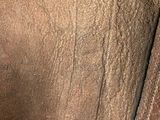 the back of a brown leather jacket with a zipper on it
