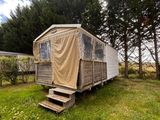 une photo d'un mobil-home au milieu d'un champ