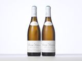 two bottles of white wine sitting on top of a table