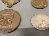 three medals and a medal on a table with a coin
