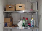 a metal shelf with boxes and cleaning products on it