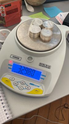 une balance sur laquelle sont posées de nombreuses pièces