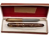 a pen and a ballpoint pen sitting in a box