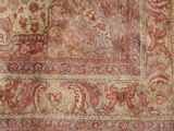 an old carpet with a red and beige design on it