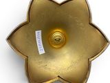 brass flower shaped candle holder with label on white background