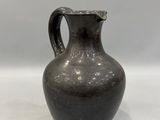 a black vase that is sitting on a white surface