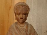 a small statue of a woman sitting on a table