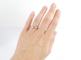 a woman ' s hand that is holding a wedding ring