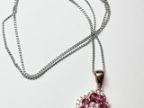 collier composé de pierres roses et blanches montées sur une chaîne, présenté sur un fond blanc