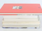 books stacked on top of each other on a white surface
