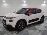 une voiture Citrole blanche et rouge garée dans un garage
