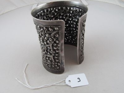 a silver bracelet that is on a table with a price tag