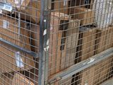 many boxes in a metal cage on a cart