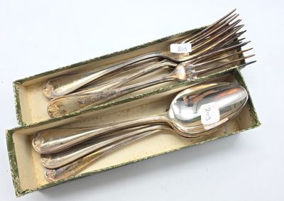 des couverts dans une boîte posée sur une surface blanche, avec une étiquette dessus