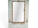 un miroir blanc et doré posé sur un meuble en bois