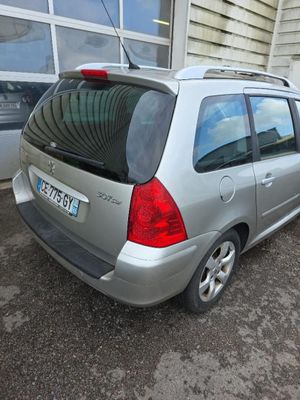 une petite voiture argentée garée devant un immeuble
