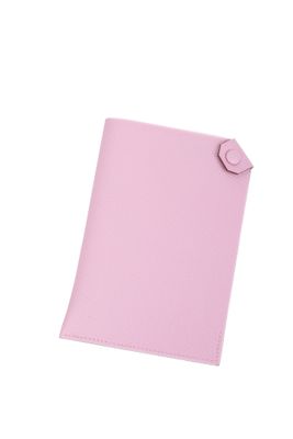 un gros plan sur un cahier rose orné d'un bouton