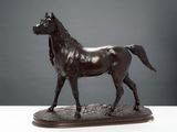 bronze statue of a horse on a wooden base on a table