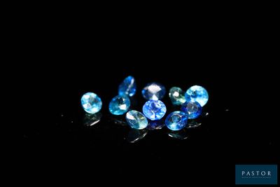 a group of blue sapphires sitting on top of a black surface