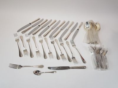 many forks and spoons laid out on the table