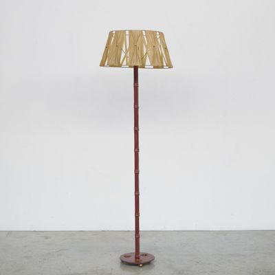 un lampadaire rouge surmonté d'un abat-jour en bambou
