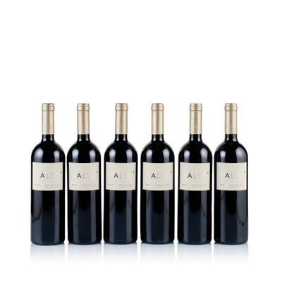 four bottles of red wine are lined up in a row