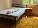 a small bed in the corner of a room with a window