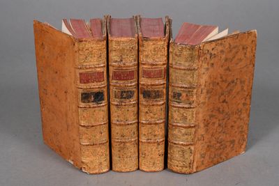 three old books are stacked on top of each other on a table