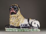 statue of a pug dog on a green base with a black and white background
