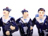 three figurines of men dressed in navy uniforms