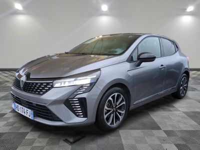une voiture grise est garée dans une grande pièce au sol en damier