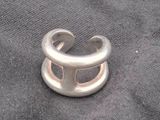 silver ring with a hole in the middle of it on a black cloth