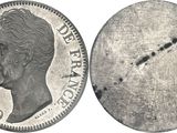 a close up of a silver coin with a face on it