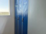 two blue lockers in the corner of a room