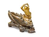 bronze statue of a mermaid sitting on a rock with a shell