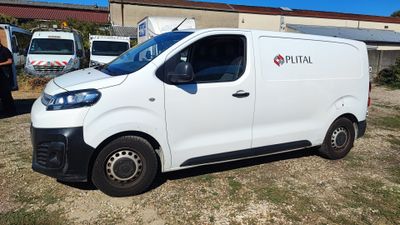 une camionnette blanche garée devant un bâtiment