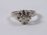 a close up of a diamond ring on a white surface