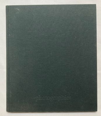 un vieux livre posé sur une table, à côté d'une nappe blanche