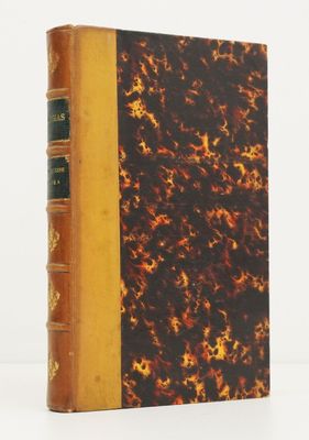 un vieux livre à la couverture marron posé sur une table blanche