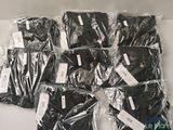 many bags of black clothing wrapped in plastic