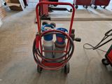 a red cart with a gas can on it in a garage