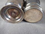 two silver salt and pepper shakers sitting on a table