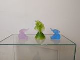 three figurines of elephants on a glass table
