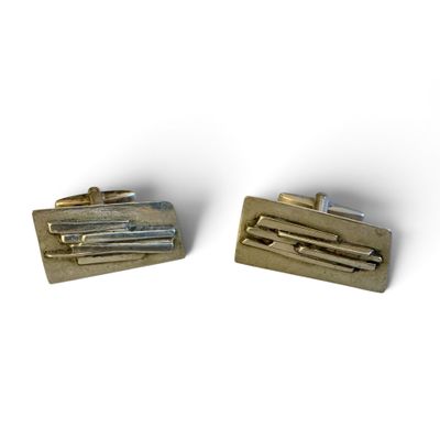 deux paires de boutons de manchette en or sur fond blanc
