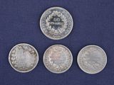 three silver coins sitting next to each other on a blue surface