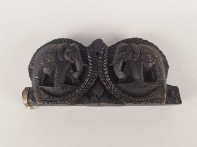 paire d'éléphants sculptés posés sur un socle en bois, sur un fond blanc