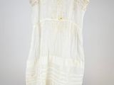 an image of a white dress hanging on a wooden hanger