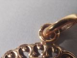 a close up of a gold plated pendant on a table
