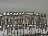 a lot of silver spoons and forks on the table