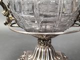 an antique silver plated bowl on a stand on a table